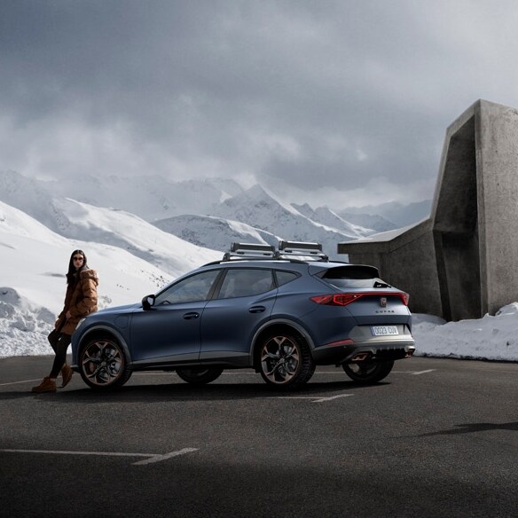 CUPRA Formentor w kolorze Petrol Blue Matt na parkingu na tle ośnieżonych wzgórz