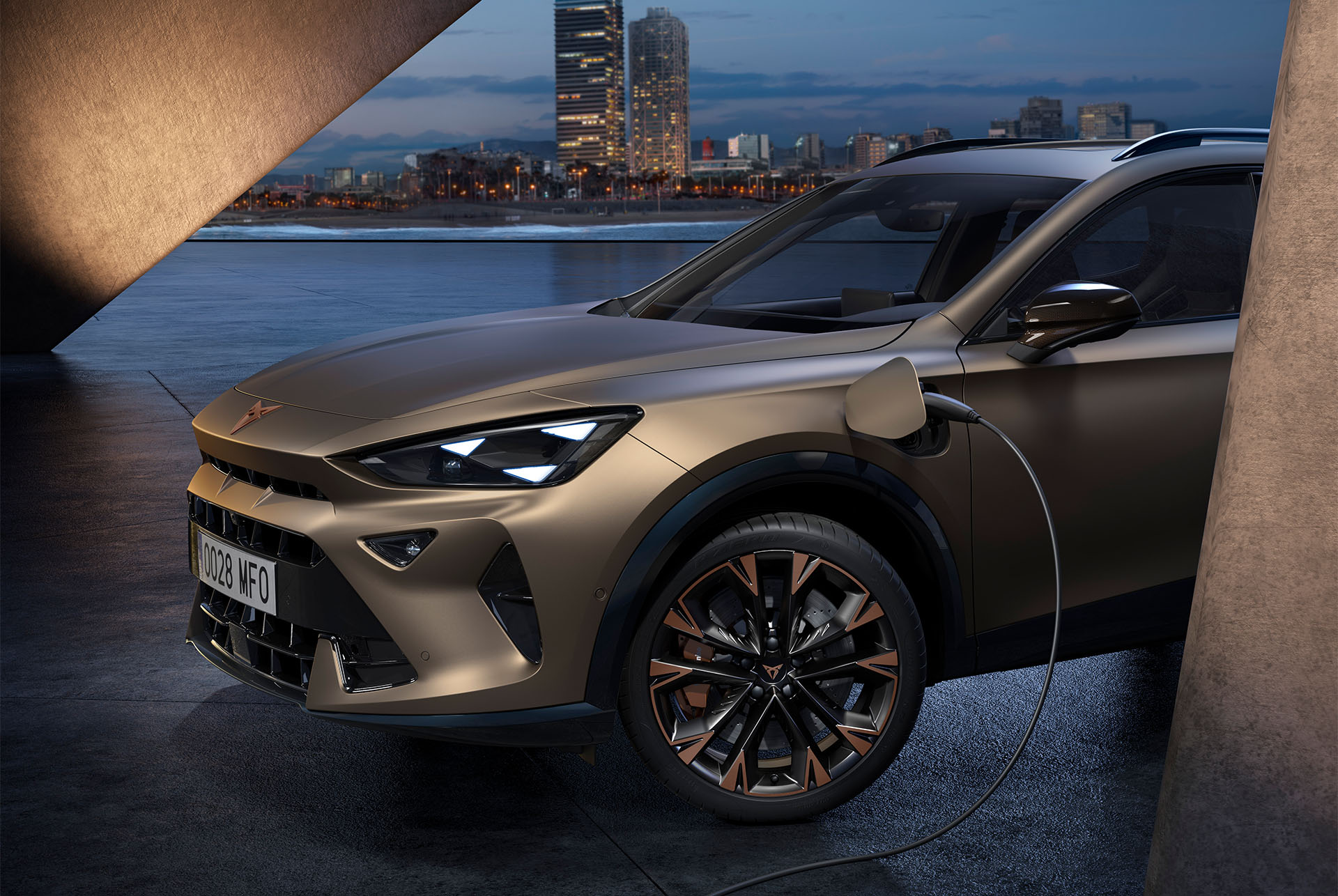 front left side view of the new century bronze matt cupra formentor 2024 with copper accent wheels, on charge, Barcelona cityscape background view at dusk.