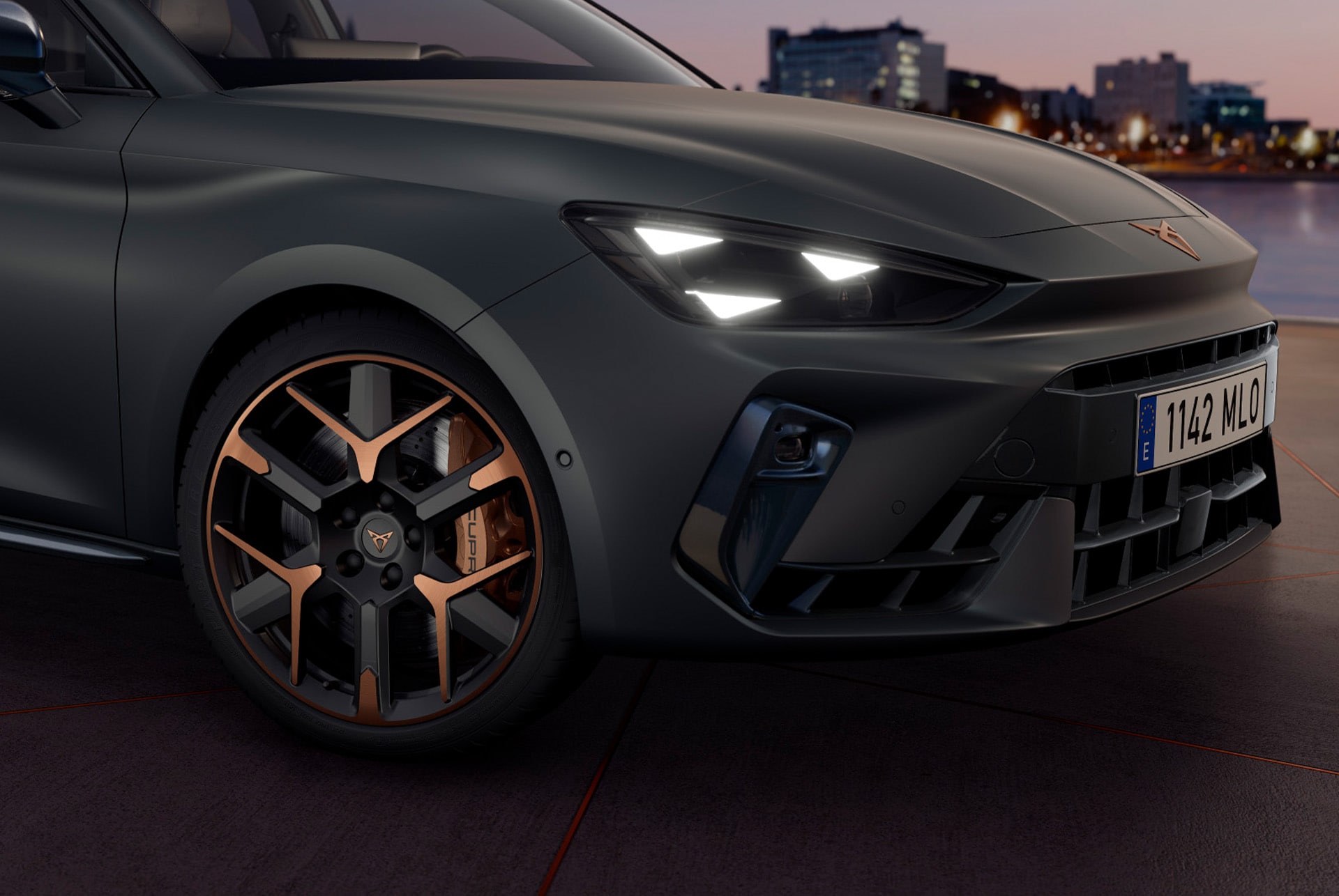 CUPRA Leon Sportstourer zbliżenie na miedziane akcenty i czarne koło oraz trójkątne reflektory cupra, karoseria w kolorze Encladus Grey Matt